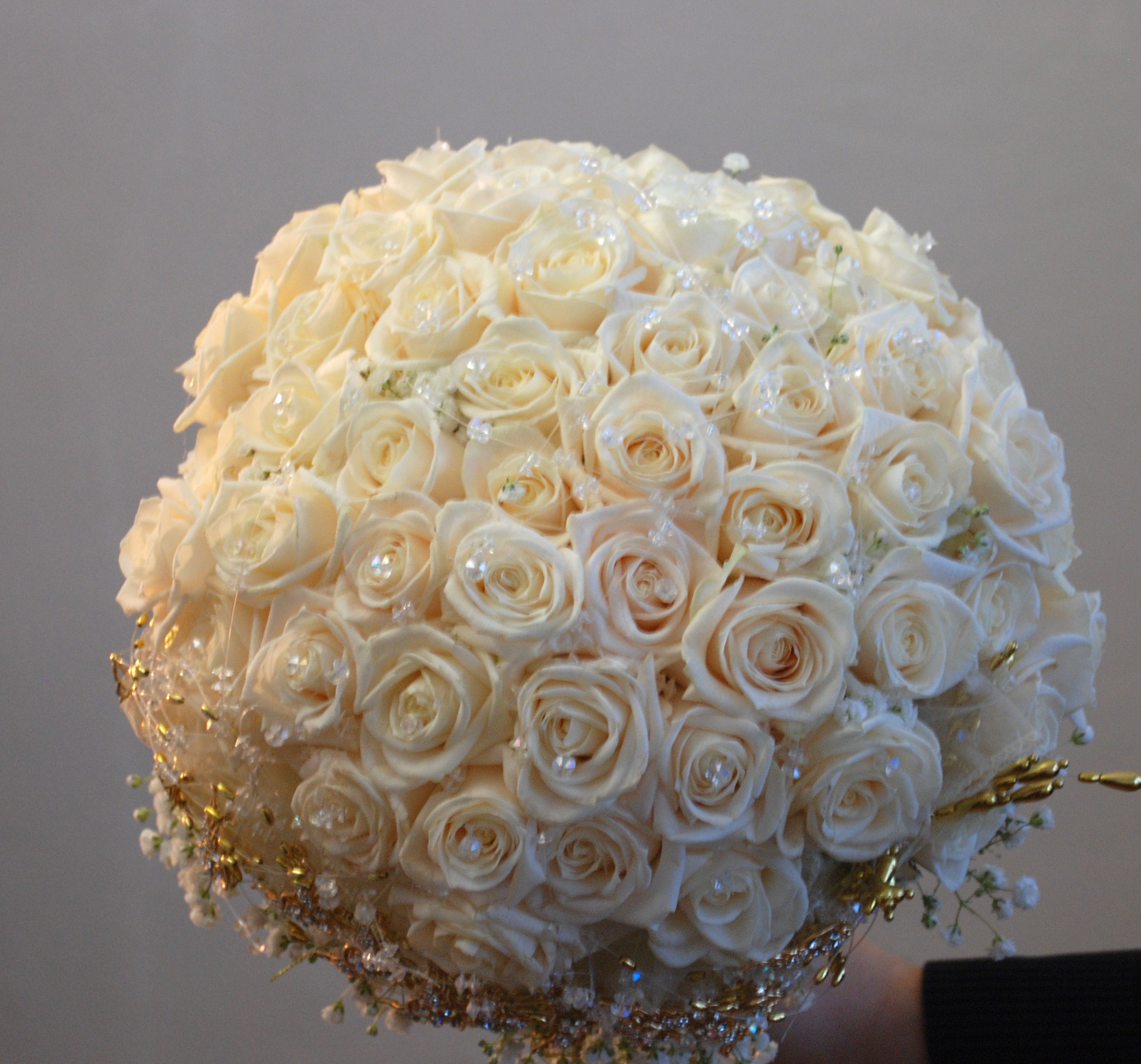 Kytice pro nevěstu z živých květin a zlatými broži